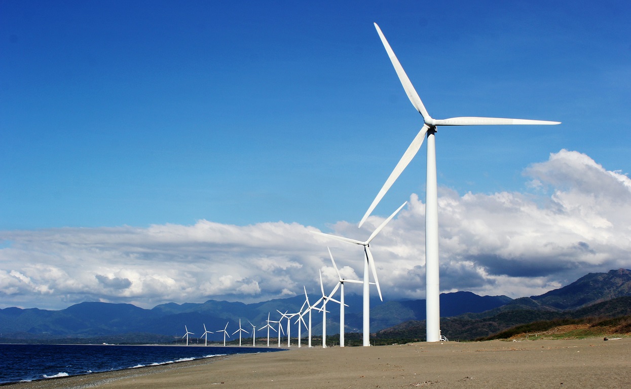 https://www.pexels.com/photo/white-wind-turbines-on-gray-sand-near-body-of-water-3976320/
